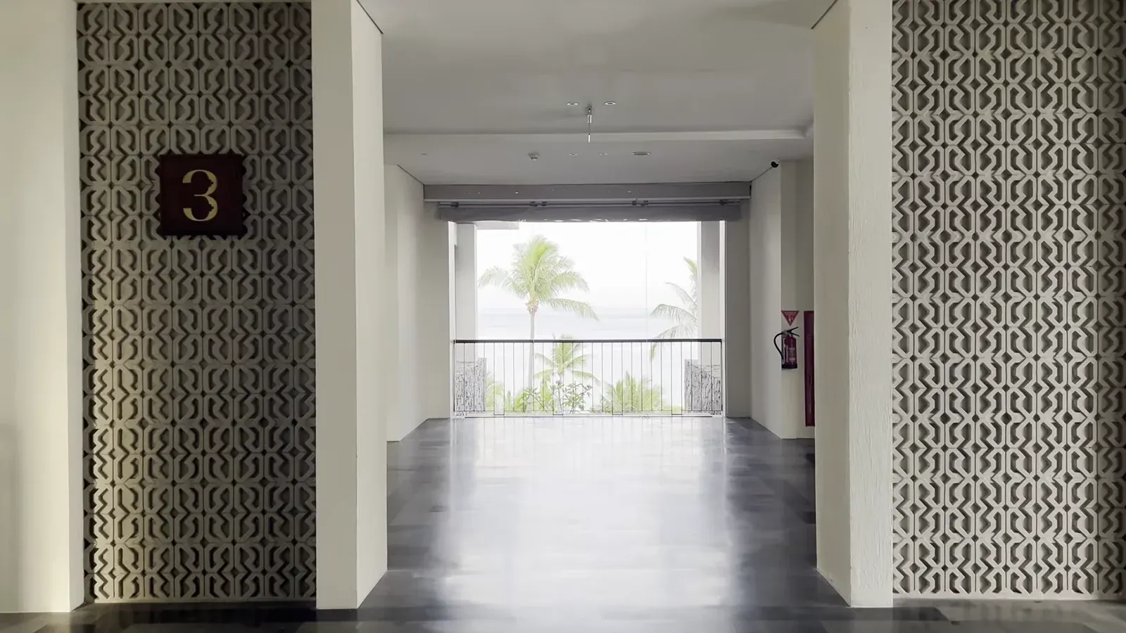 The third-floor corridor at The Sira Lombok, open to the sea at the far end