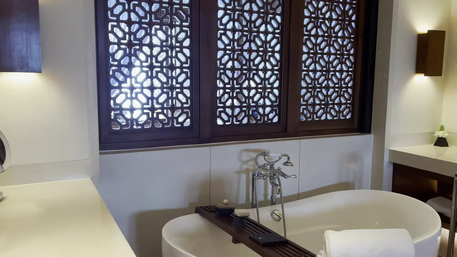The freestanding bathtub under the carved teak screen in the suite at The Sira Lombok