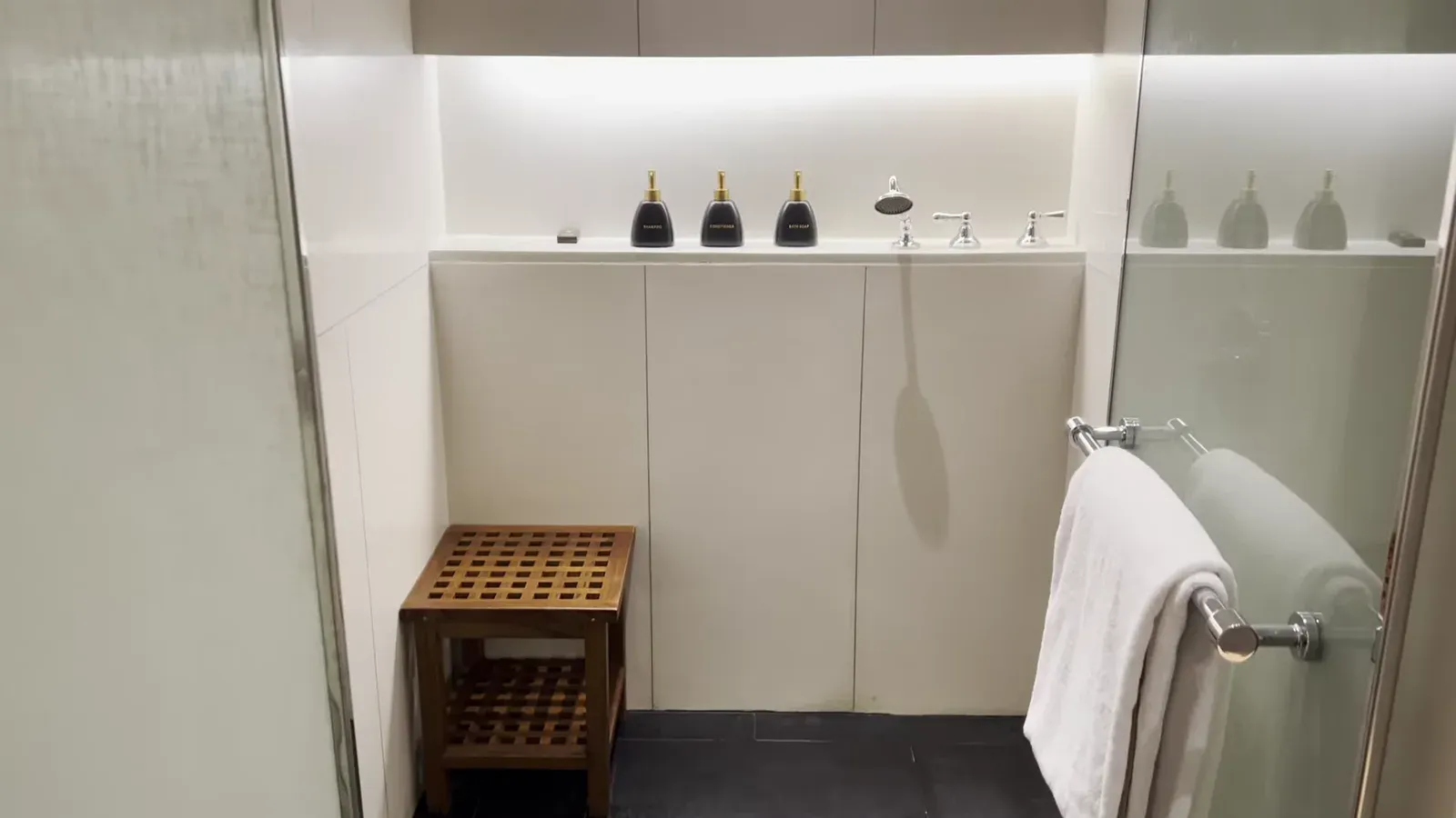 The walk-in shower room in the suite at The Sira Lombok, with rain shower and teak bench